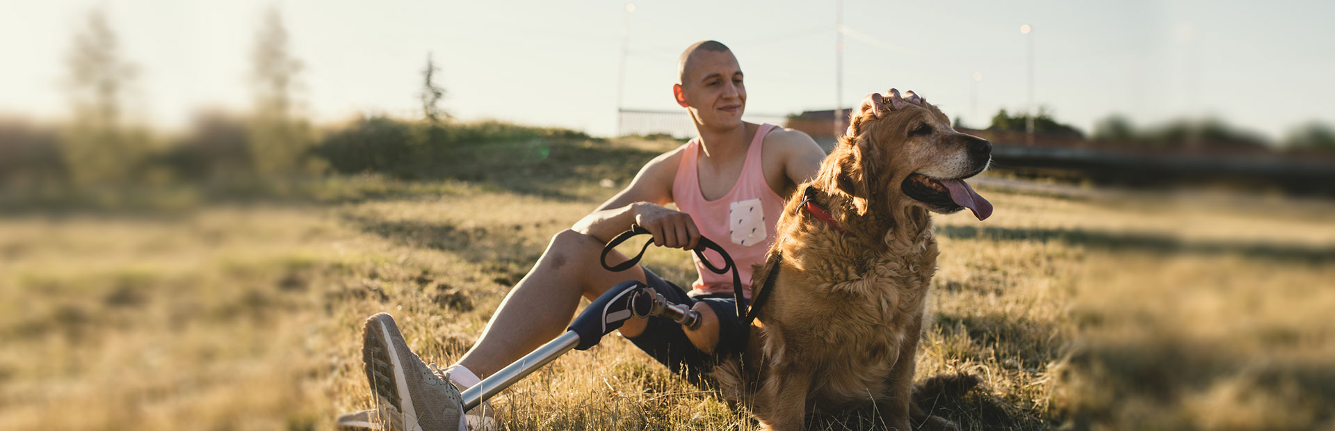 A photo of a man with a prosthetic leg and his dog