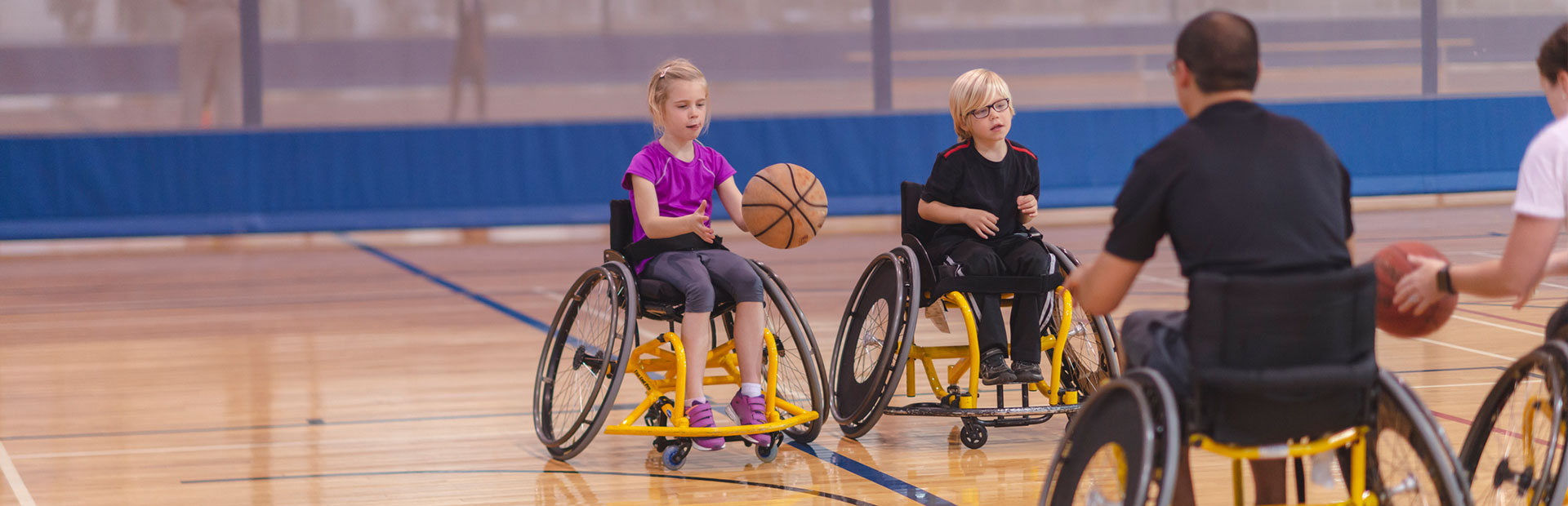 A photo of children in wheelchairs playing basketball