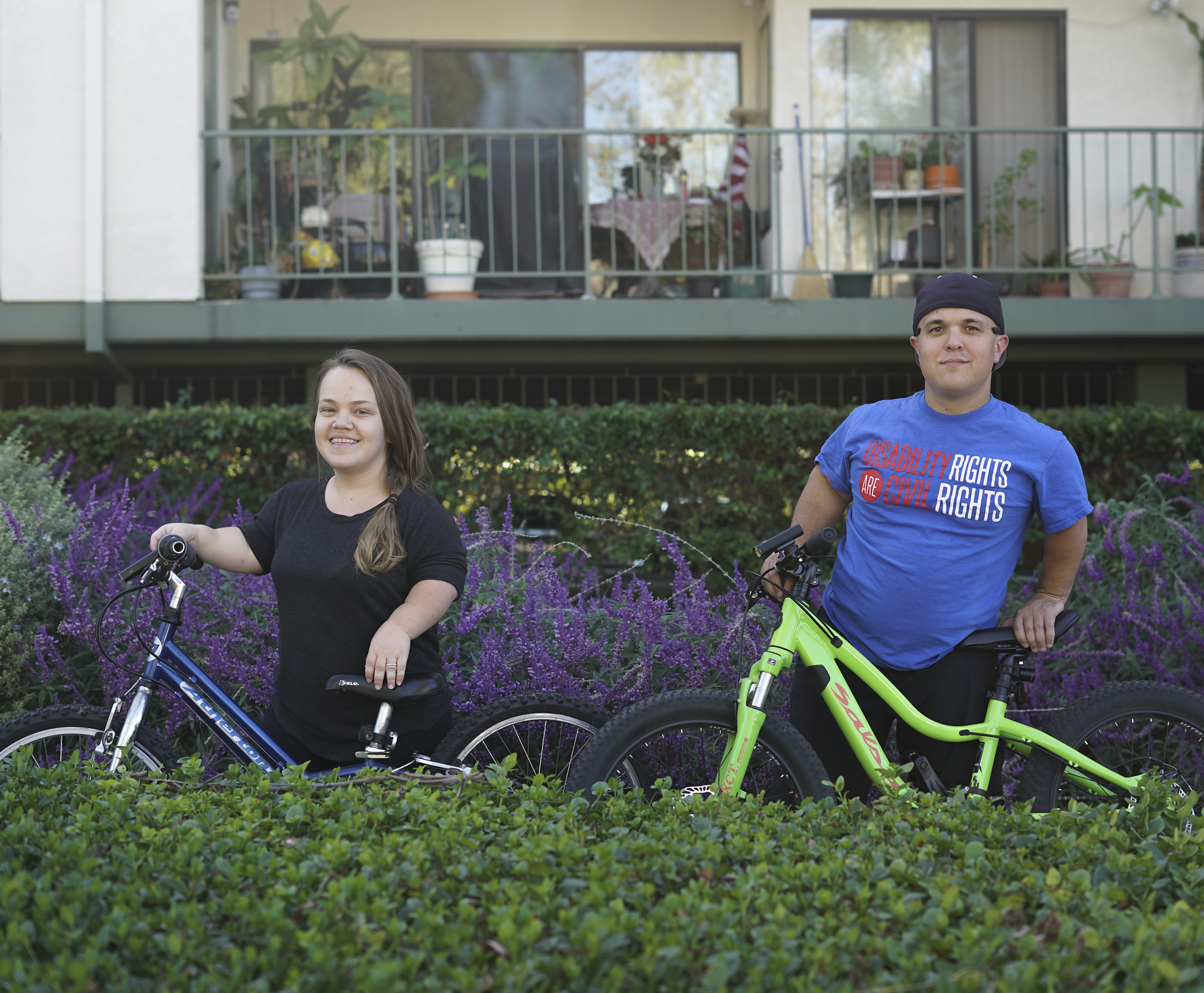 Two little people stand beside their bikes.