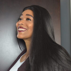 Headshot of Rose Brown. A black woman with long, straight black hair and a blazer.