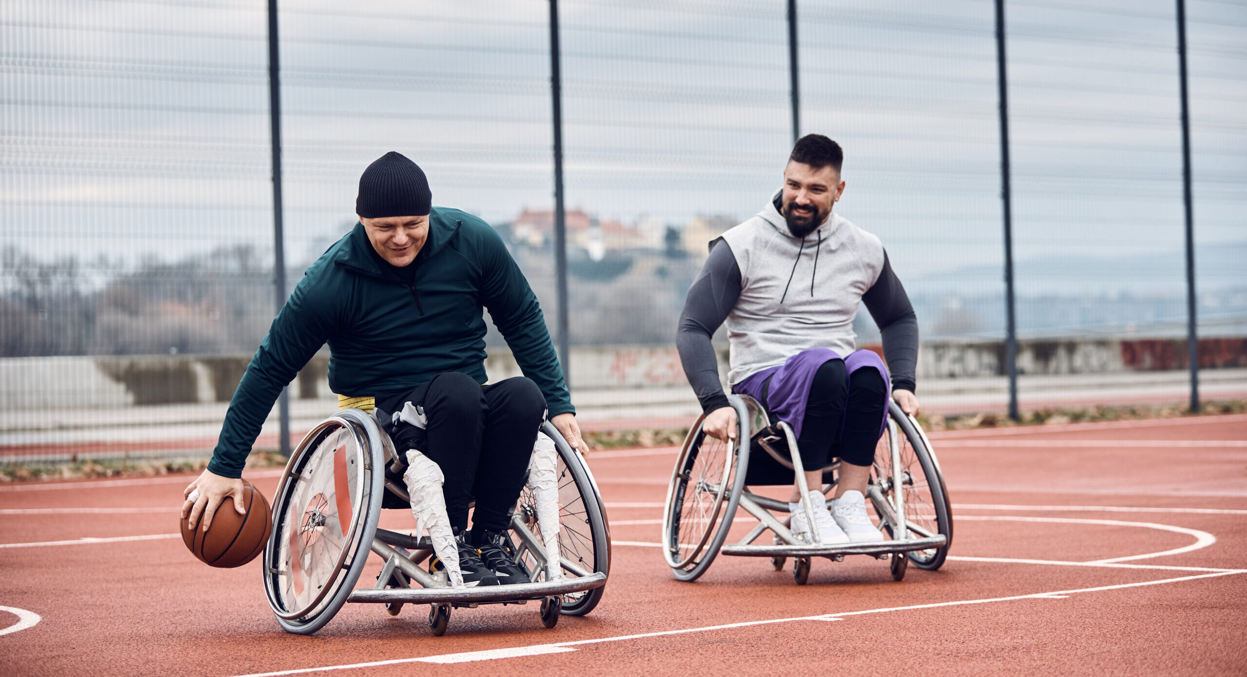 Two men in wheelchairs playing basketball.