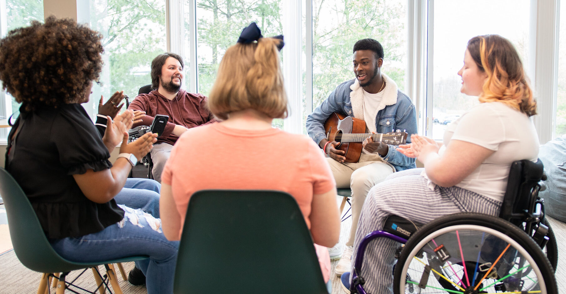 53084820388_80ea4b6754_k A group of people with disabilities seated in a circle.