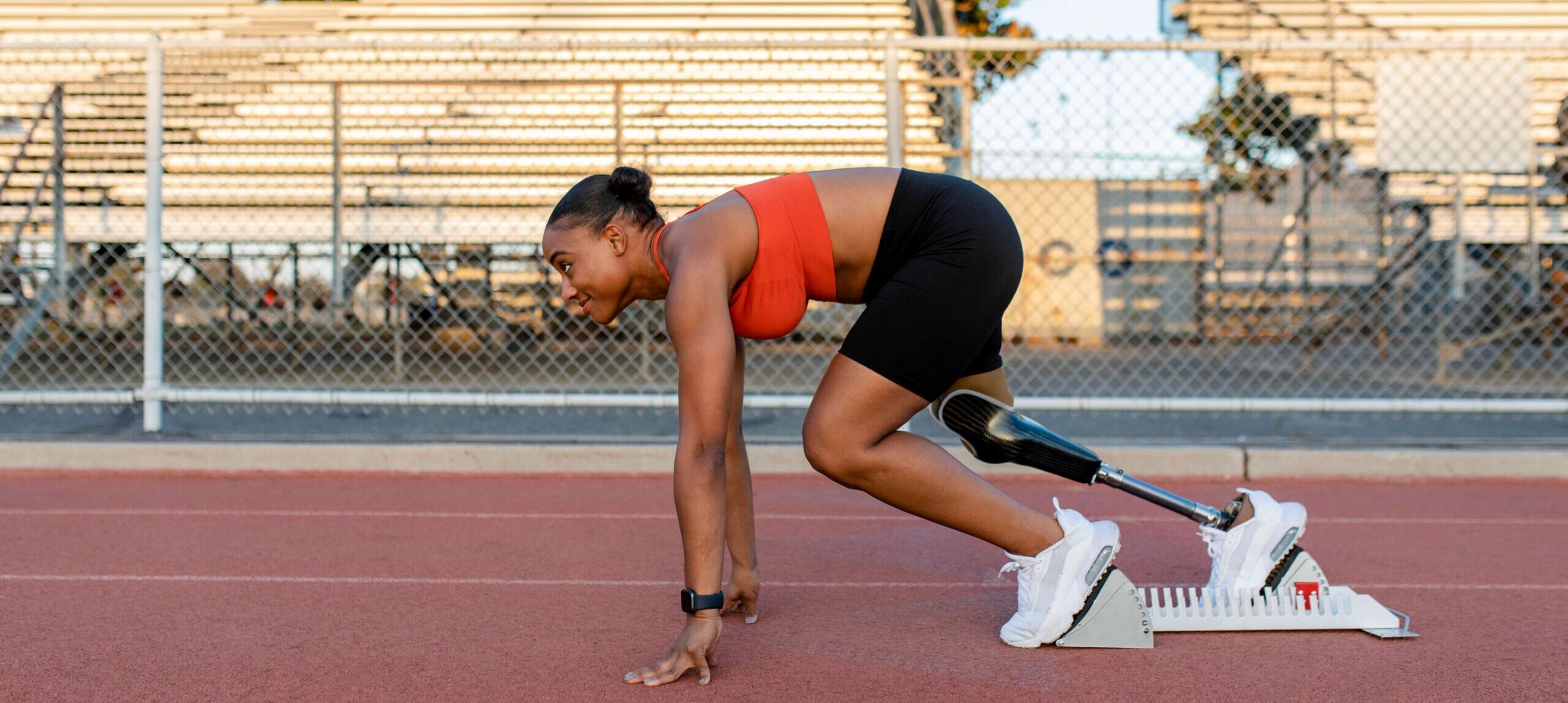 Athlete with a prosthetic leg posed in position to start a race.